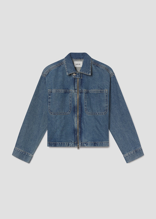 Flat lay of blue denim jacket on a light grey background