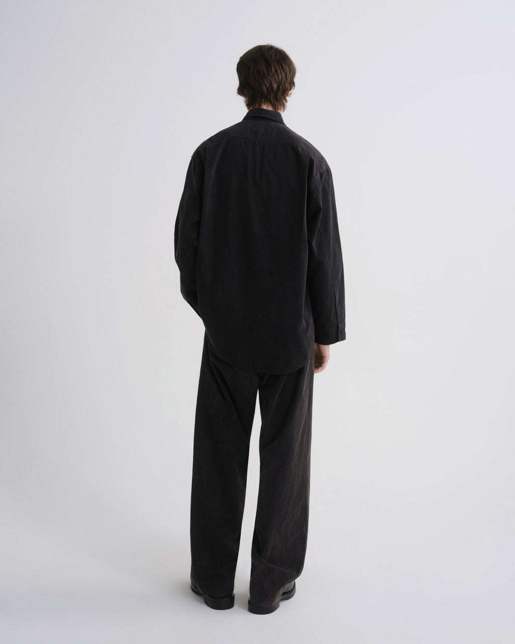 Person wearing a black outfit on a white background