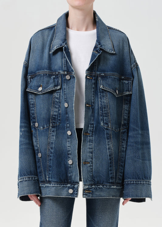Blue denim jacket worn by a person on a white background