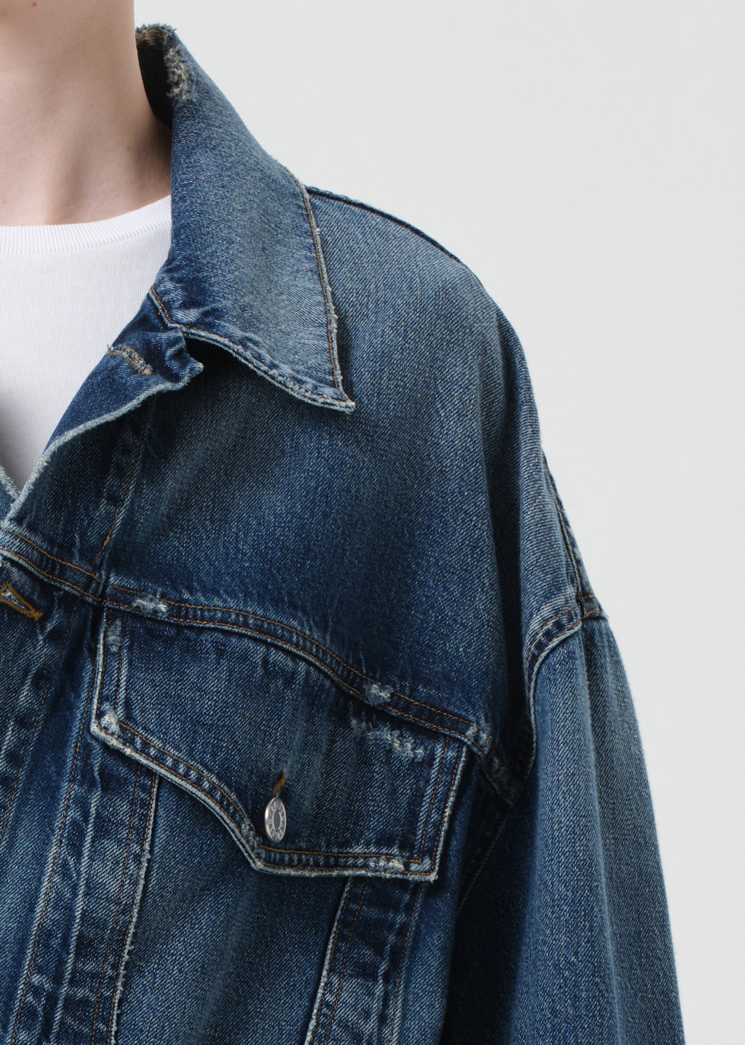 Close-up of a blue denim jacket on a plain background