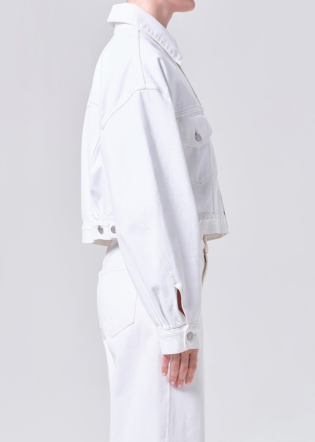 Person wearing a white outfit on a plain background