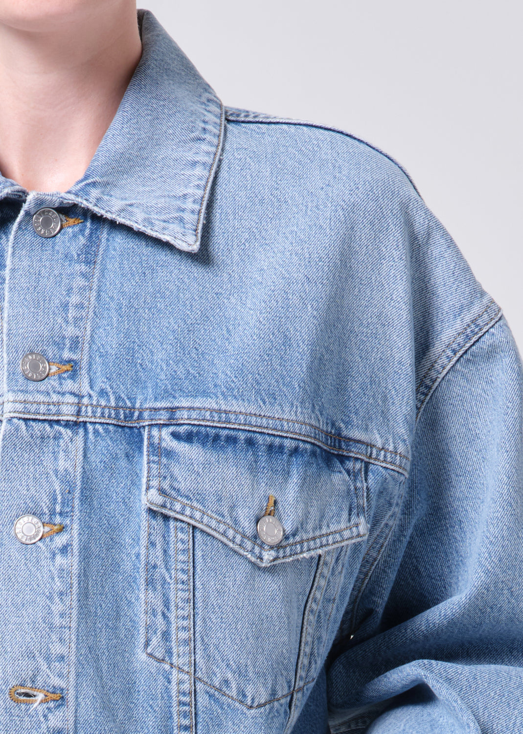 Close-up of a blue denim jacket with a neutral background