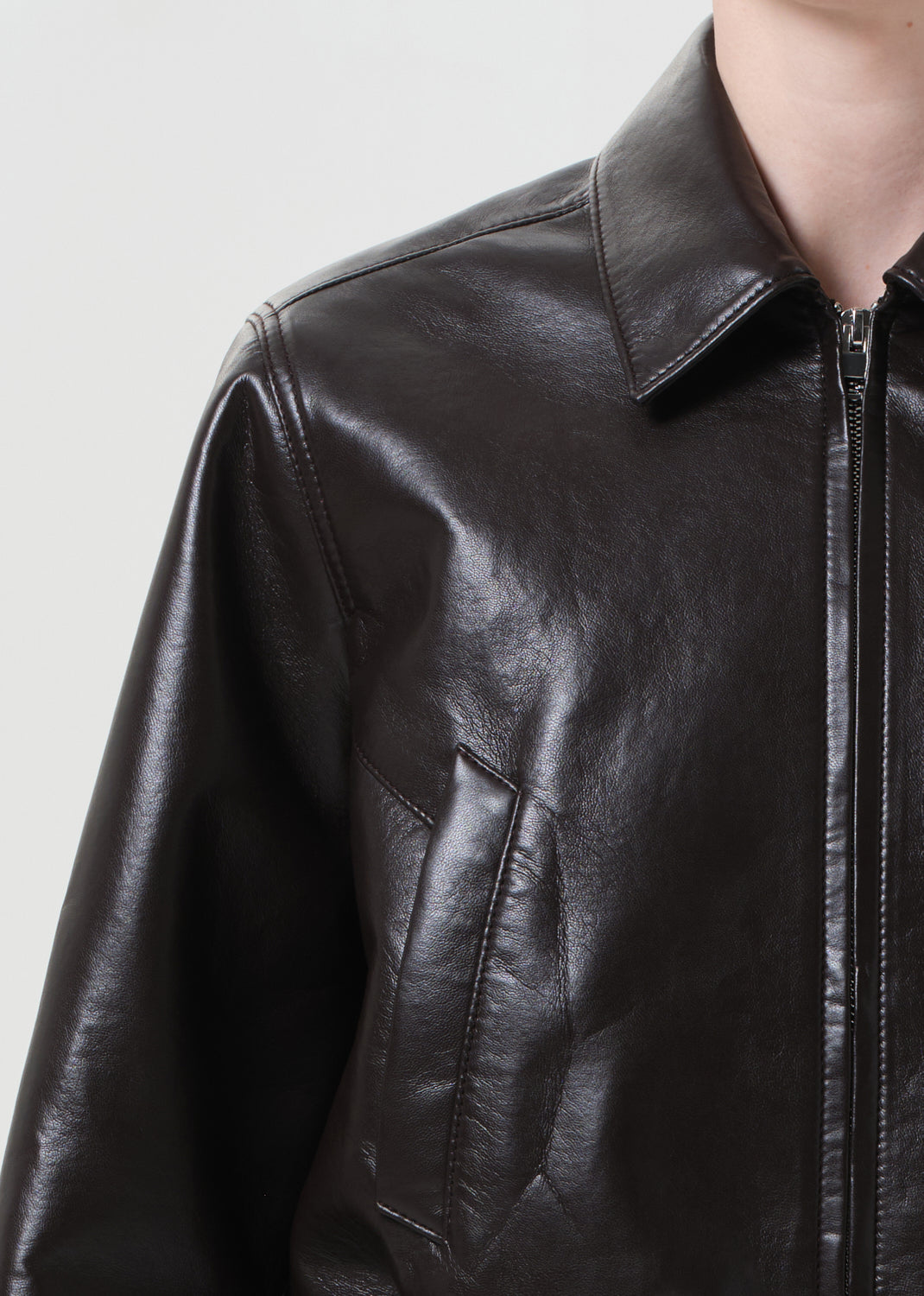 Close-up of a black leather jacket on a plain background