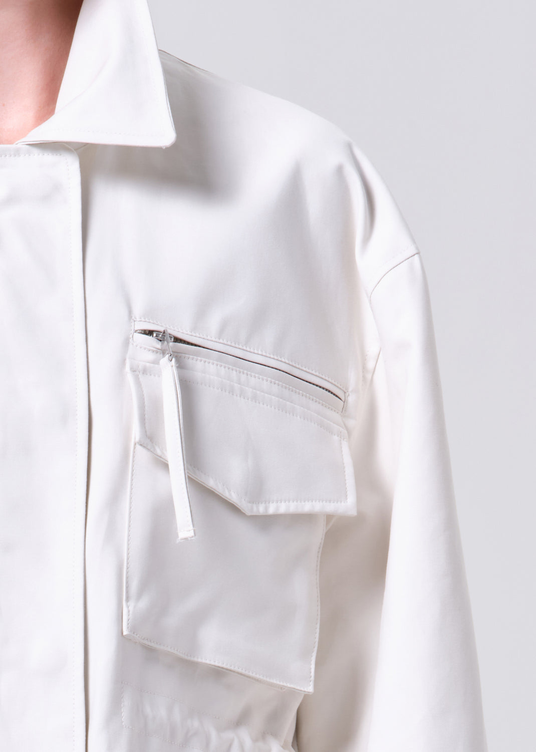 Close-up of a white shirt with a pocket on a light gray background