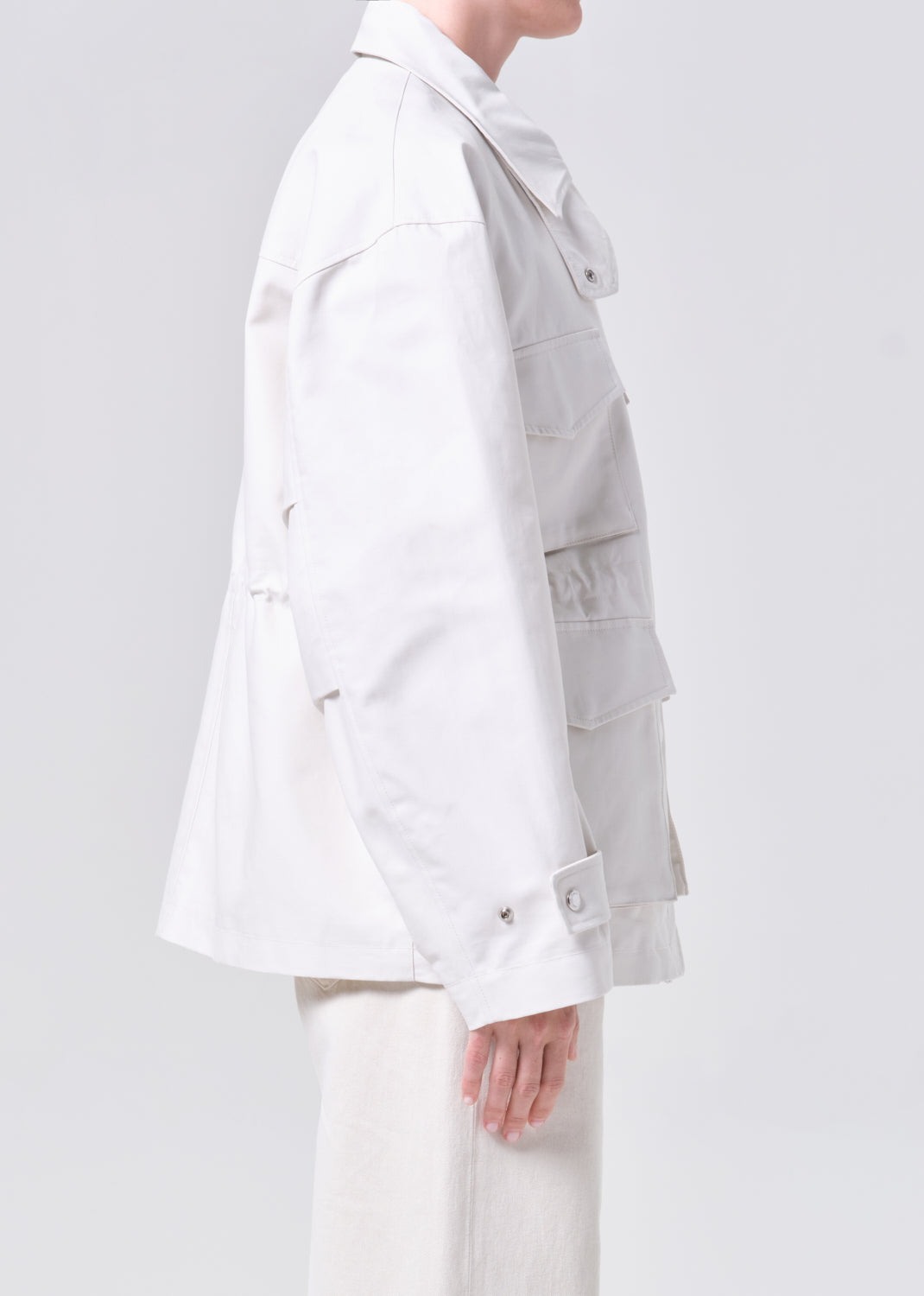 Person wearing a light gray jacket on a white background