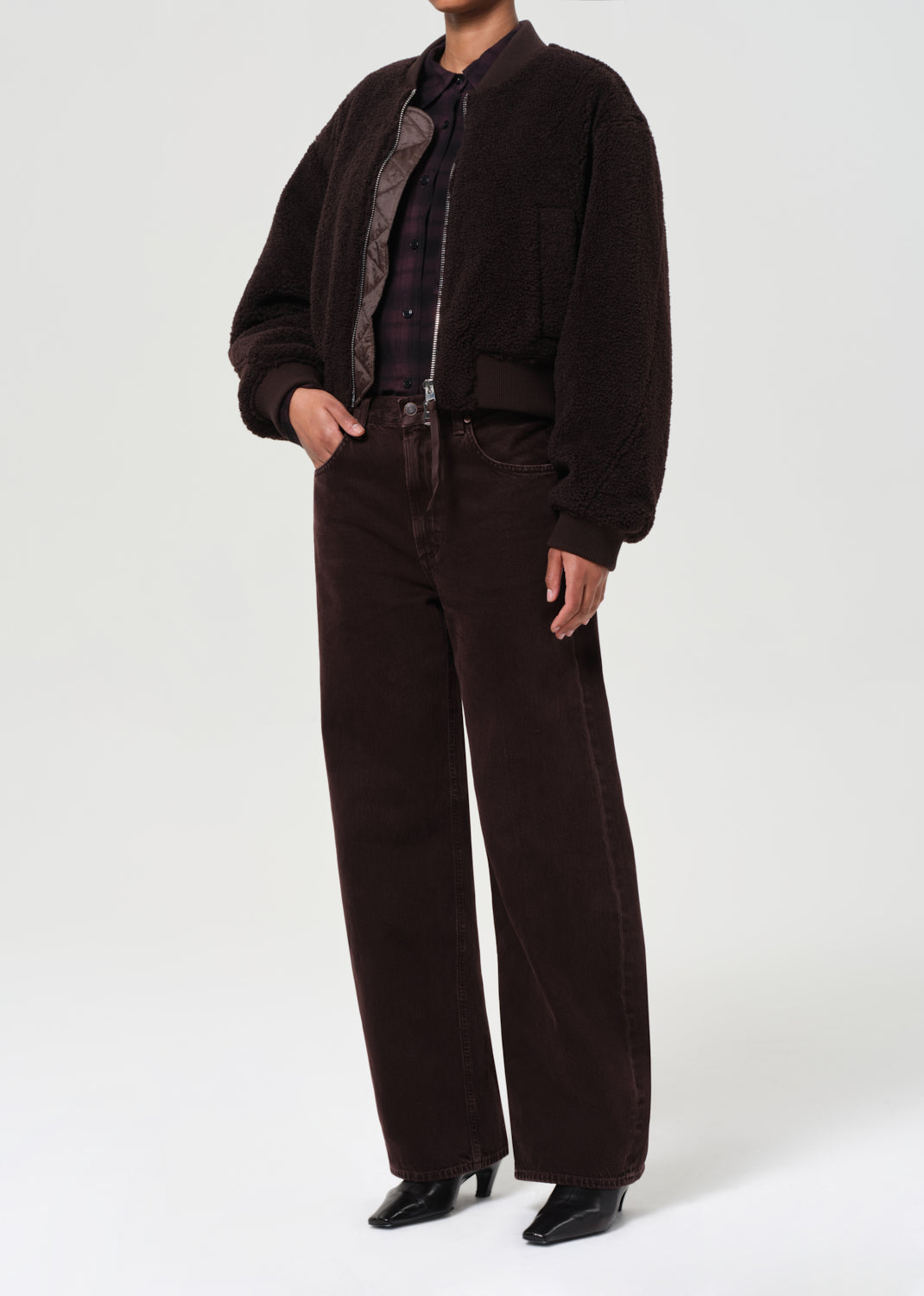 Person wearing a brown corduroy suit on a white background