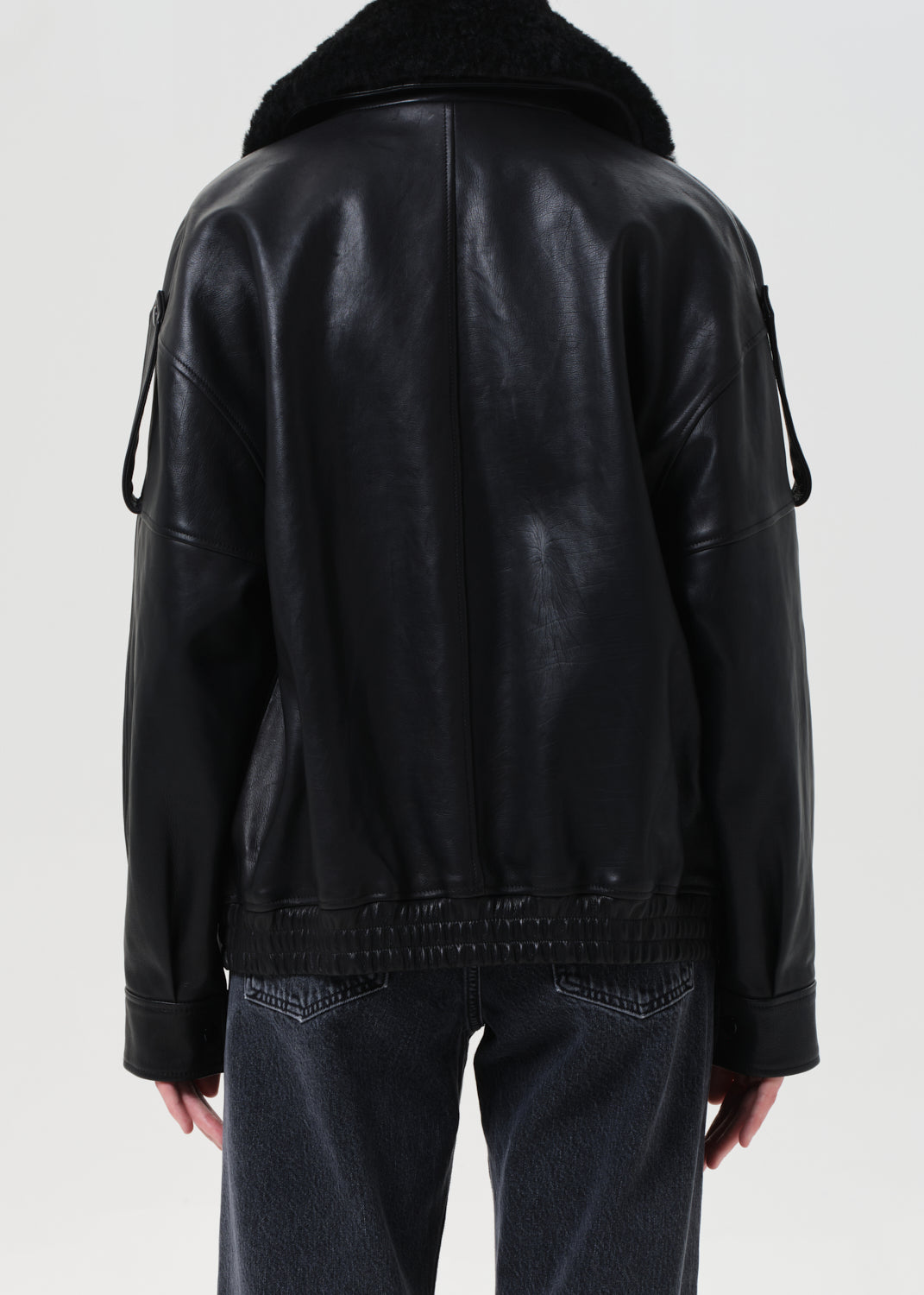 Black leather jacket worn by a person on a white background