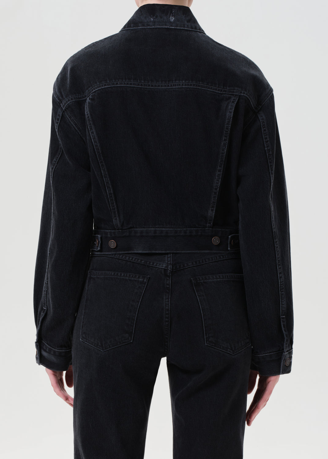 Black denim jacket worn by a person on a white background