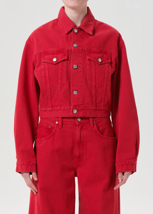 Person wearing a red denim jacket and jumpsuit on a white background