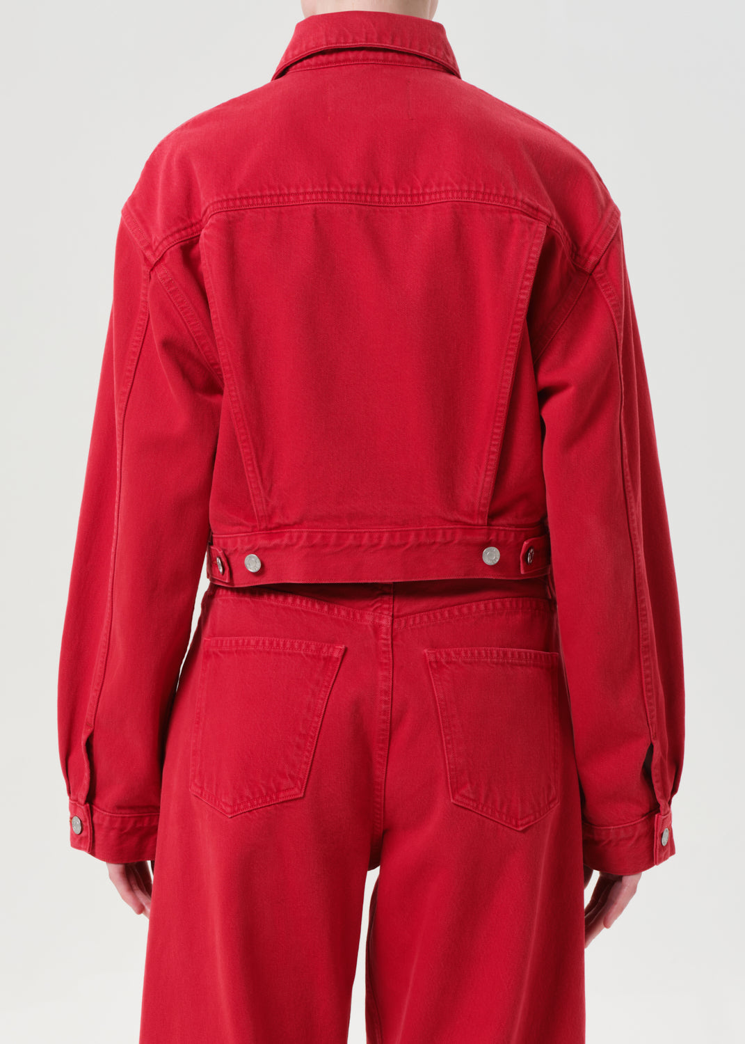 Red jacket and pants worn by a person on a white background