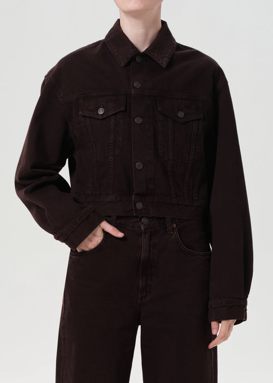 Person wearing a dark brown jacket and pants on a white background
