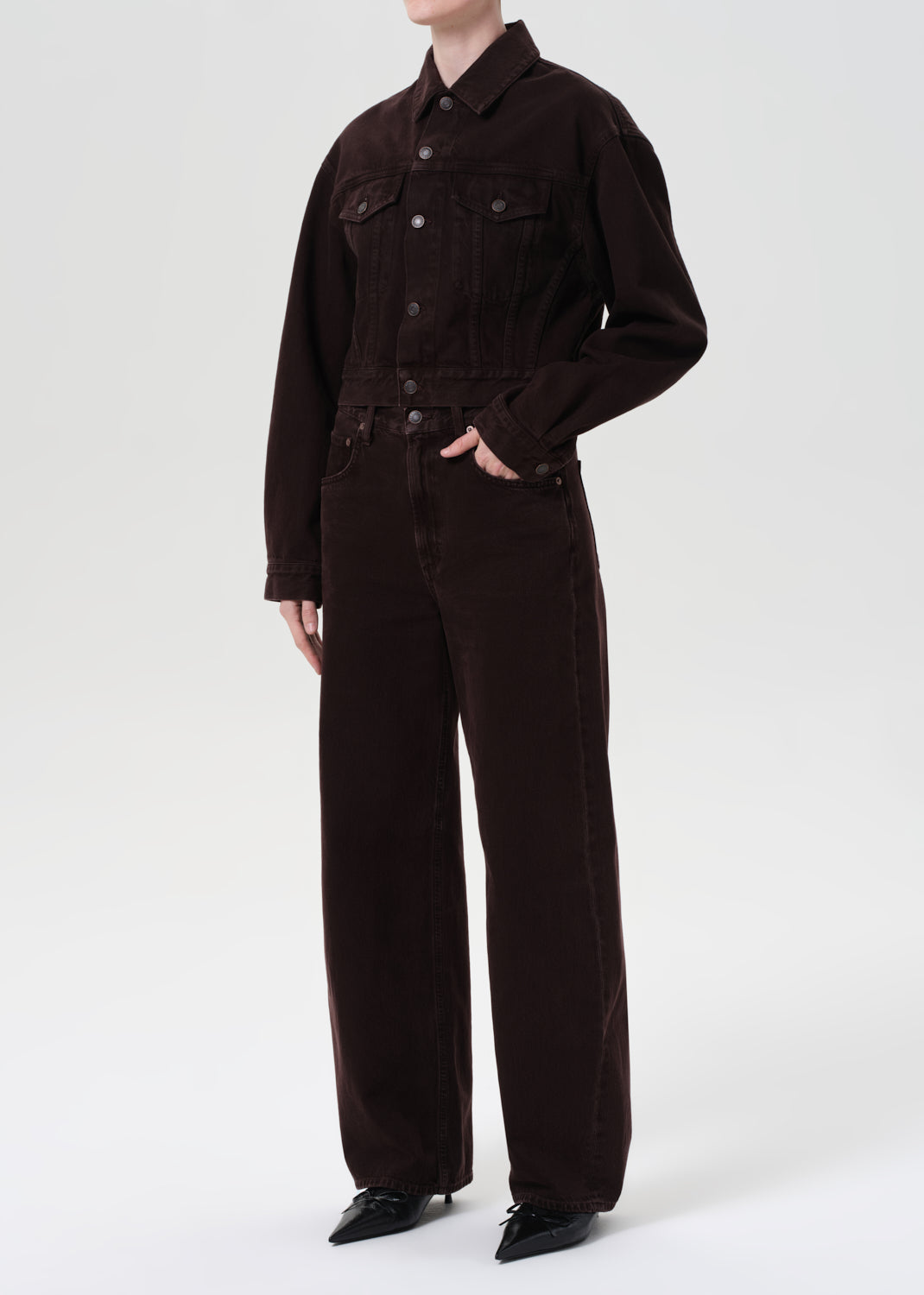 Person wearing a brown jumpsuit on a white background
