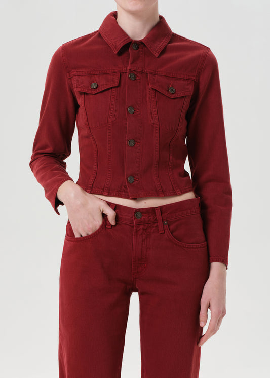 Person wearing a red denim jacket and pants on a white background