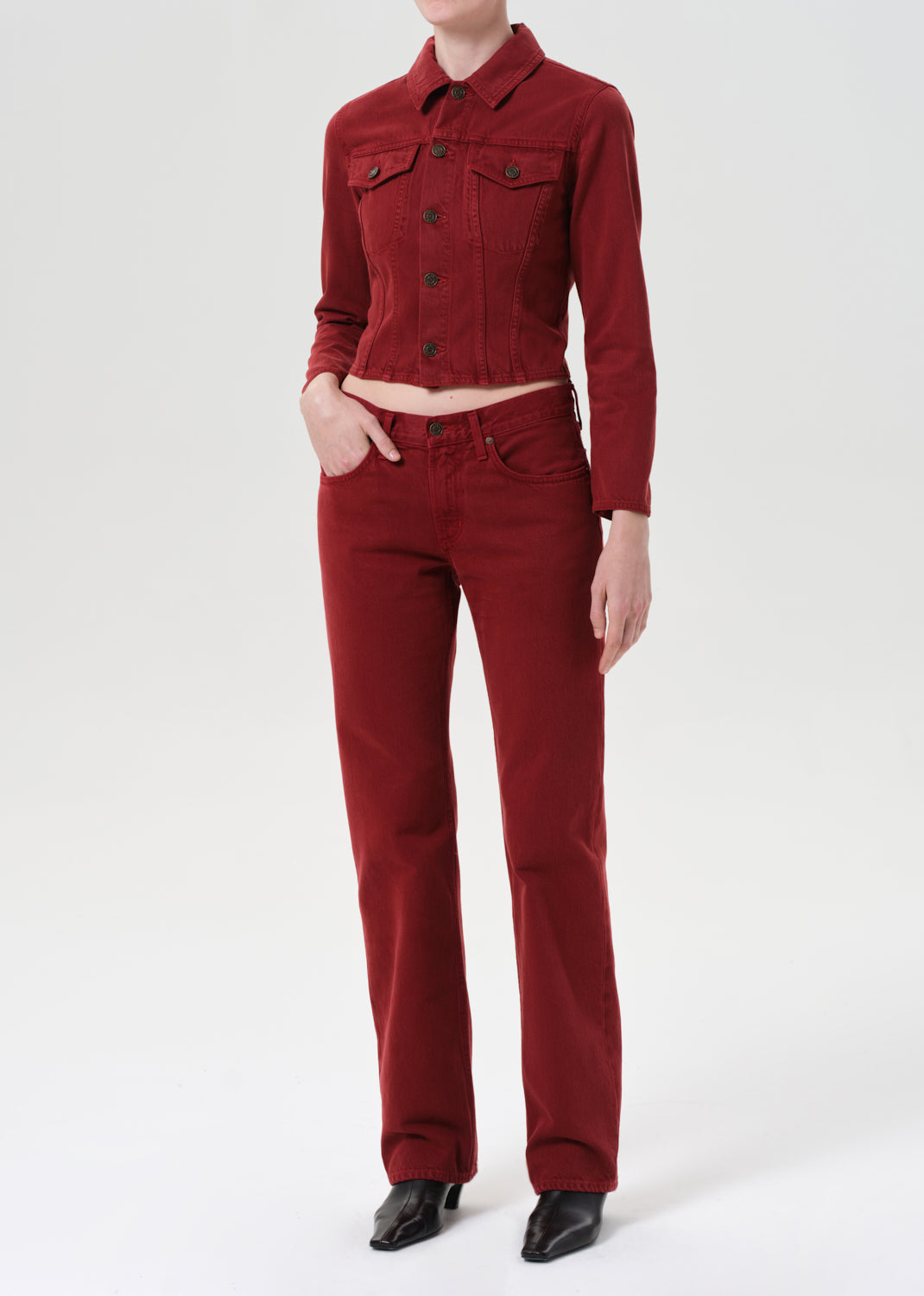 Person wearing a red corduroy jacket and pants on a white background