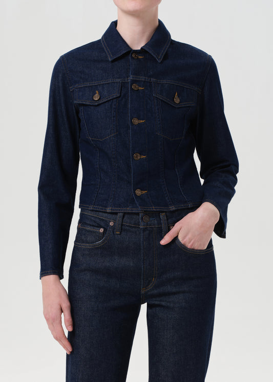 Person wearing a dark denim jacket and jeans on a white background