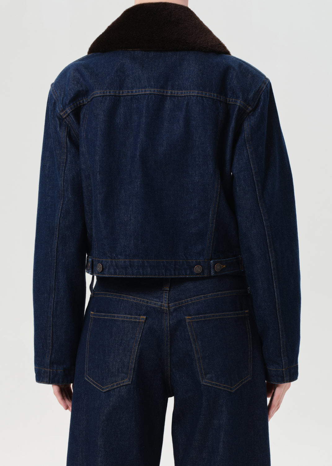 Dark blue denim jacket with a textured collar on a white background