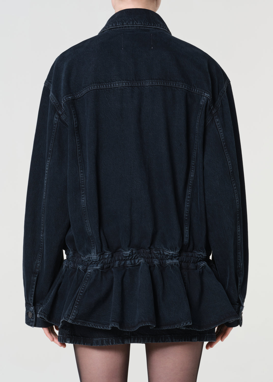 Black denim jacket with peplum waist on a plain background
