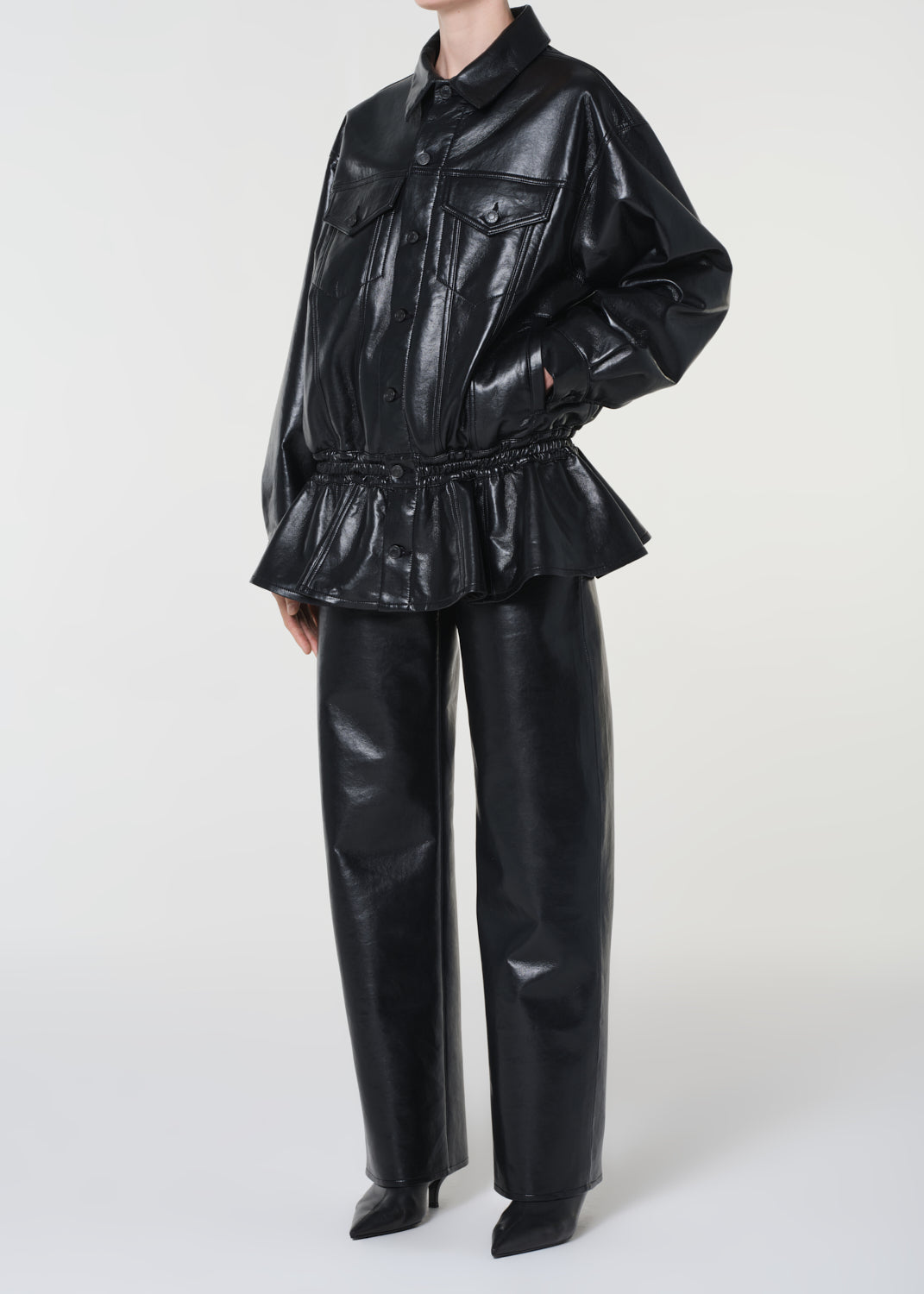 Person wearing a black leather outfit on a white background