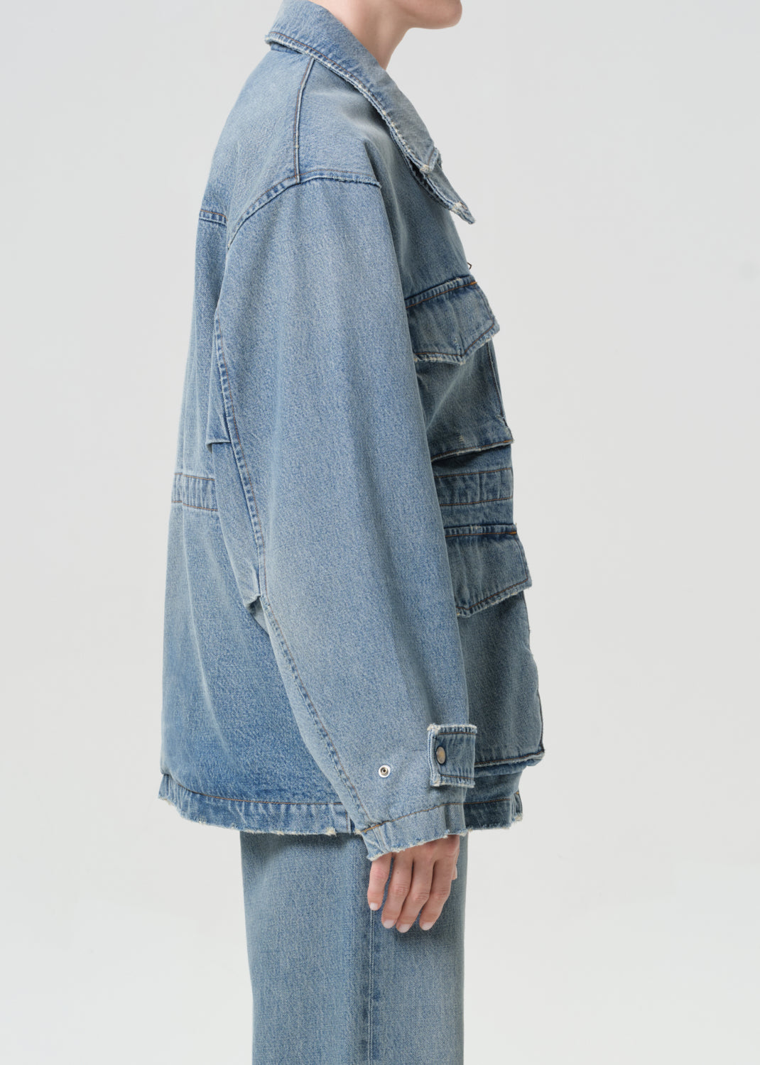 Light blue denim jacket worn by a person on a light gray background