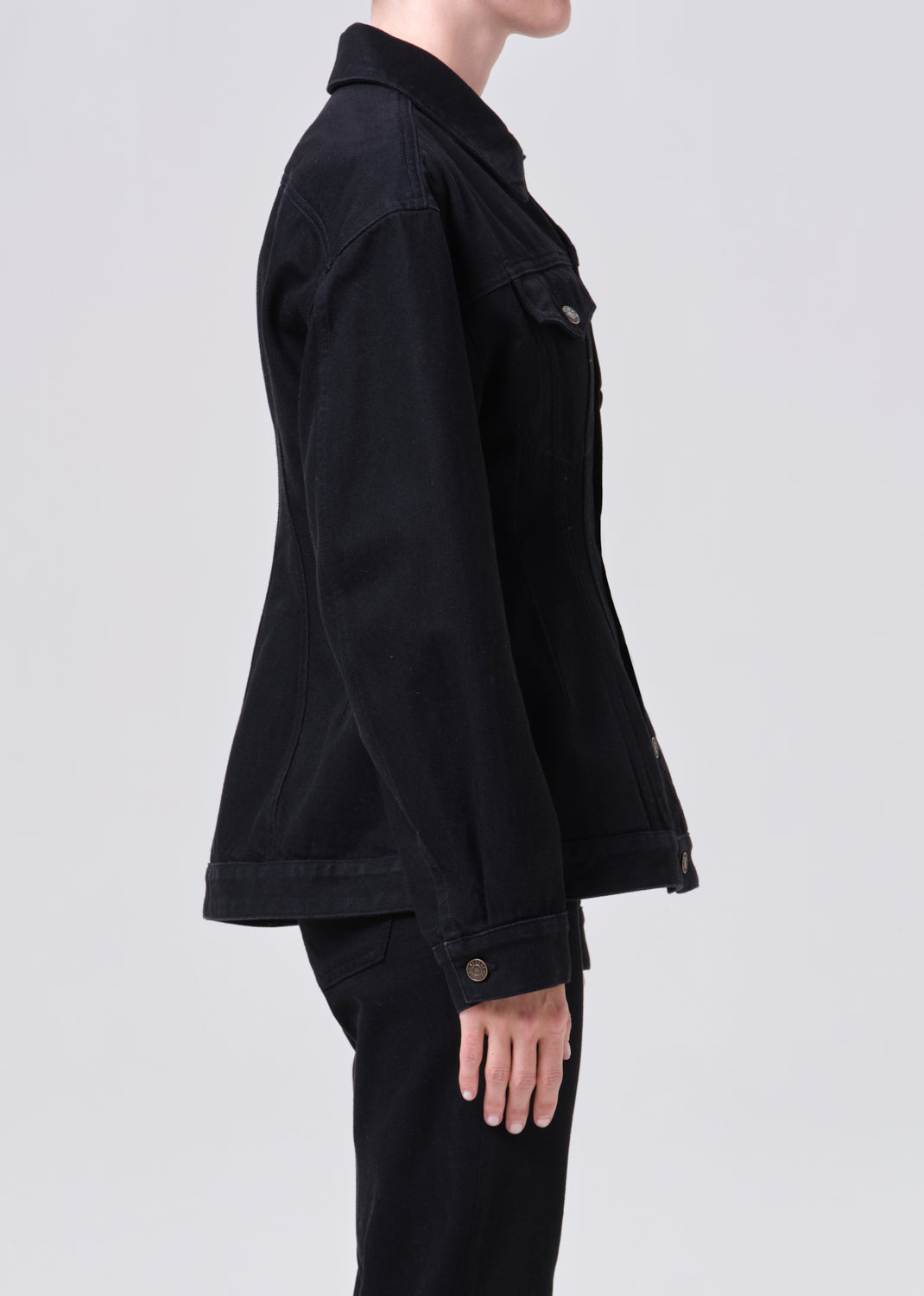 Person wearing a black jacket on a light gray background