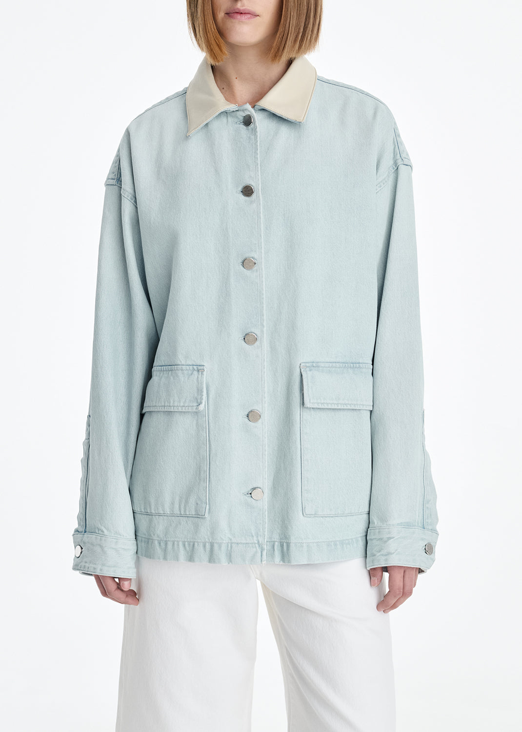 Light blue denim jacket with beige collar worn by a person on a white background