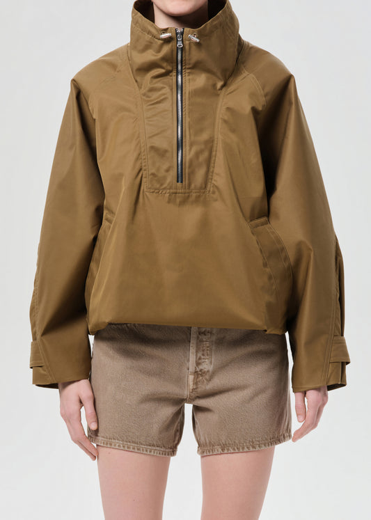 Person wearing a brown jacket and shorts on a white background