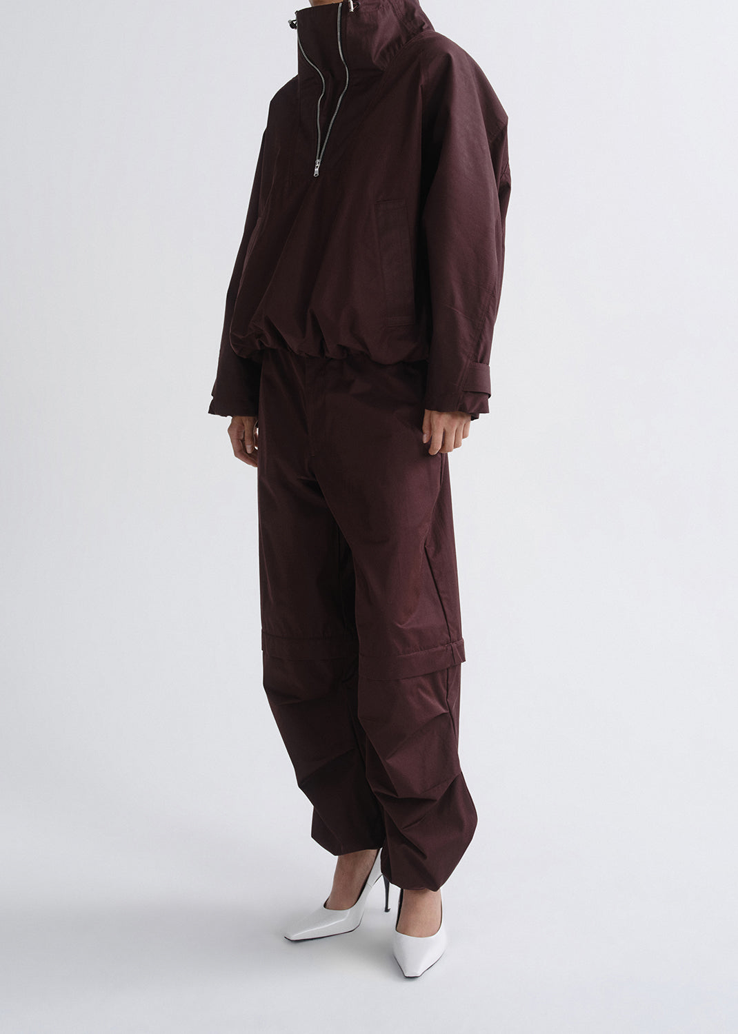 Brown tracksuit worn by a person on a grey background