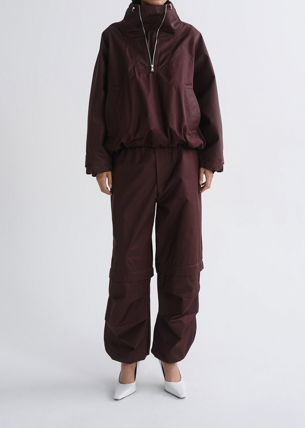 Brown tracksuit worn by a person on a grey background
