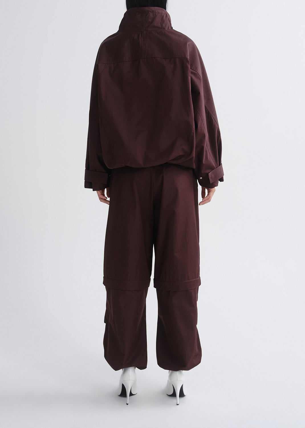 Maroon outfit with a jacket and pants on a grey background