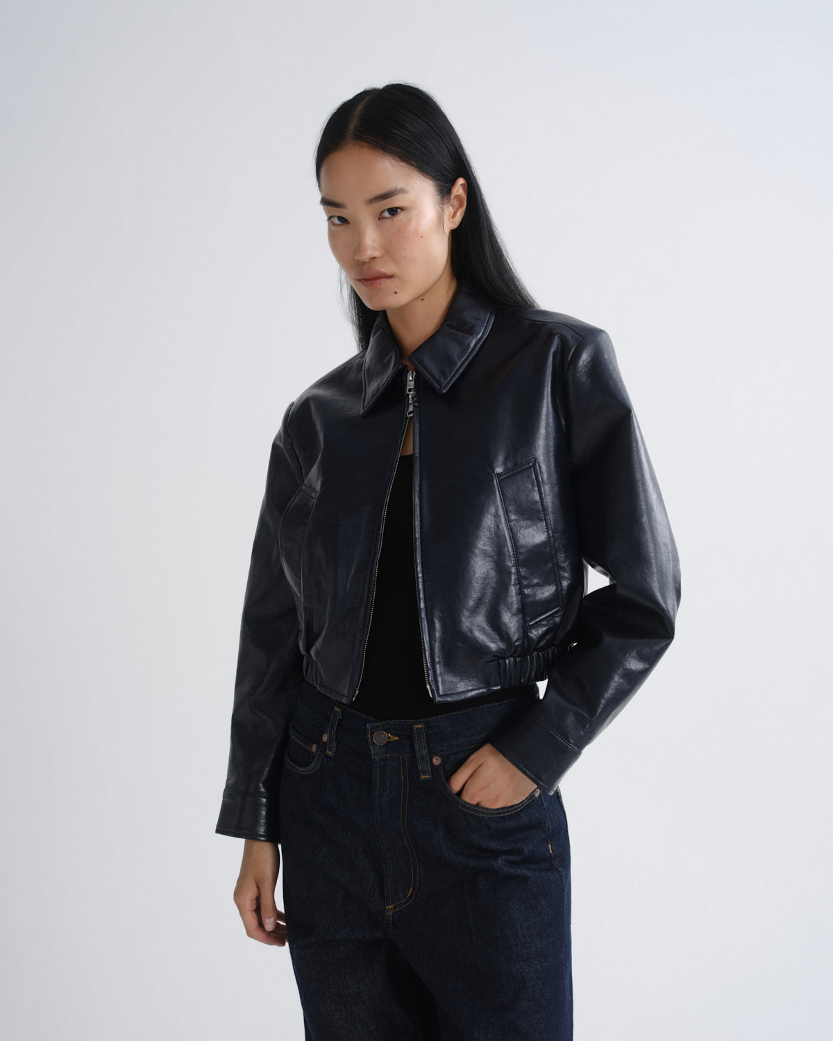 Person wearing a black leather jacket on a white background