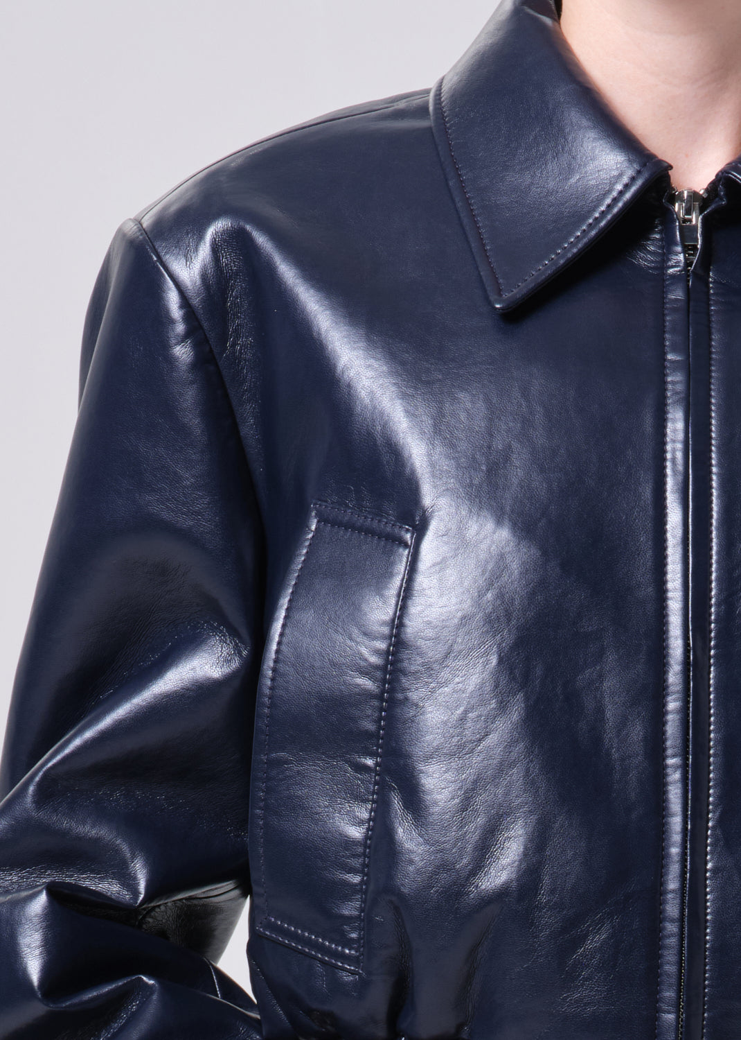 Close-up of a navy leather jacket on a plain background