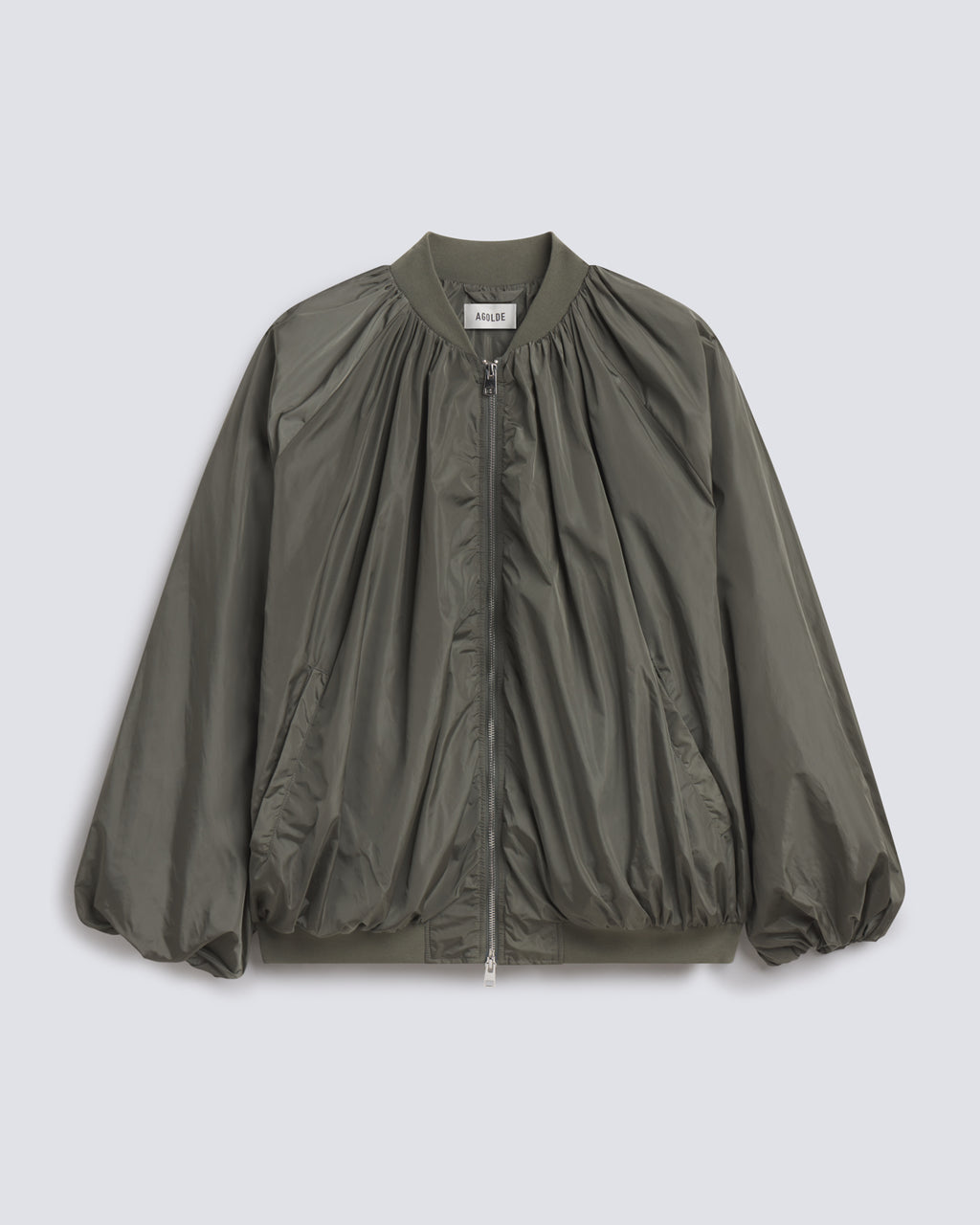 An olive green nylon bomber jacket with a gathered, pleated front design, ribbed collar, cuffs, and hem, shown flat on a light gray background.
