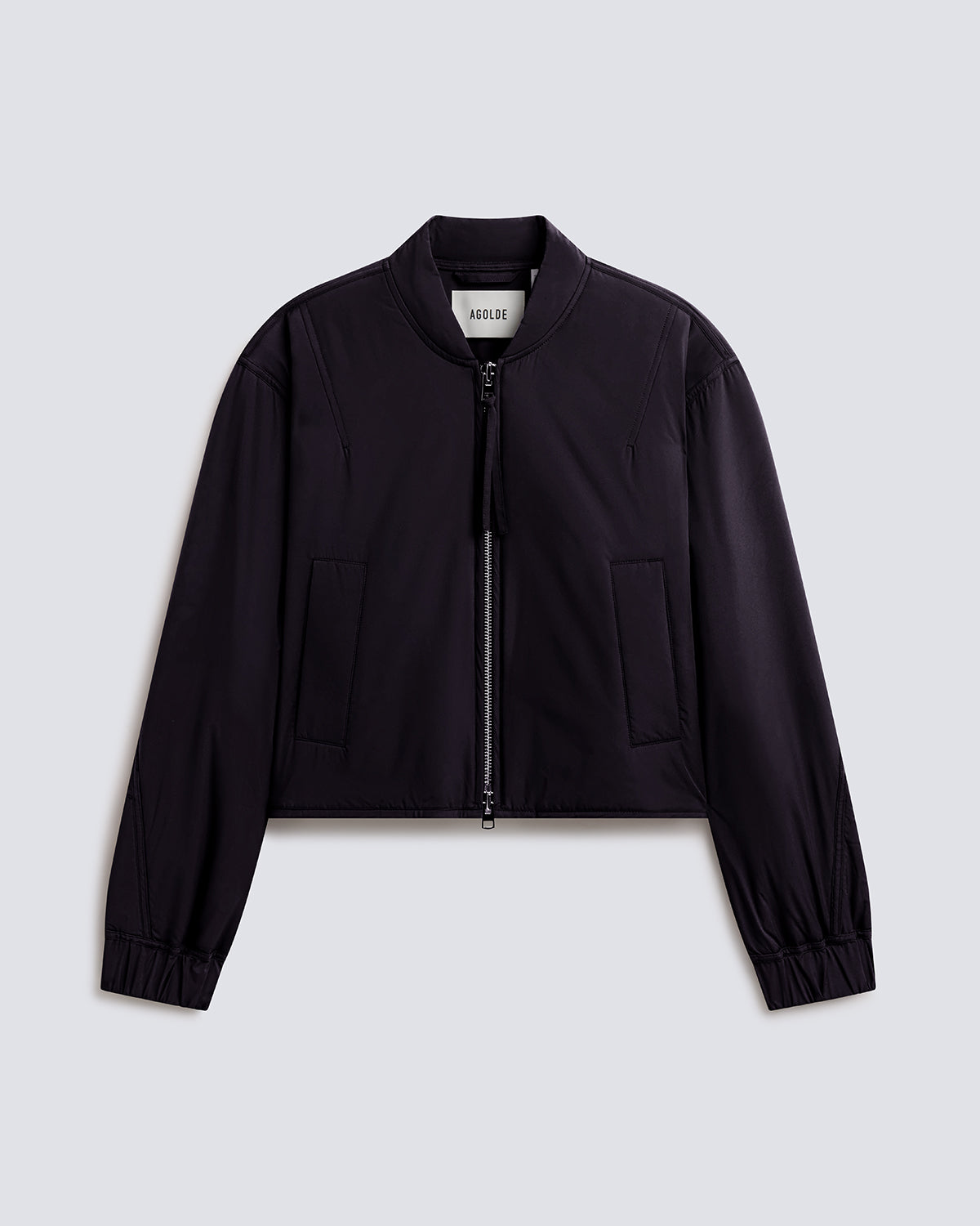 A black cropped zip-up jacket with a stand collar, long sleeves, and two front flap pockets, shown flat against a light gray background.