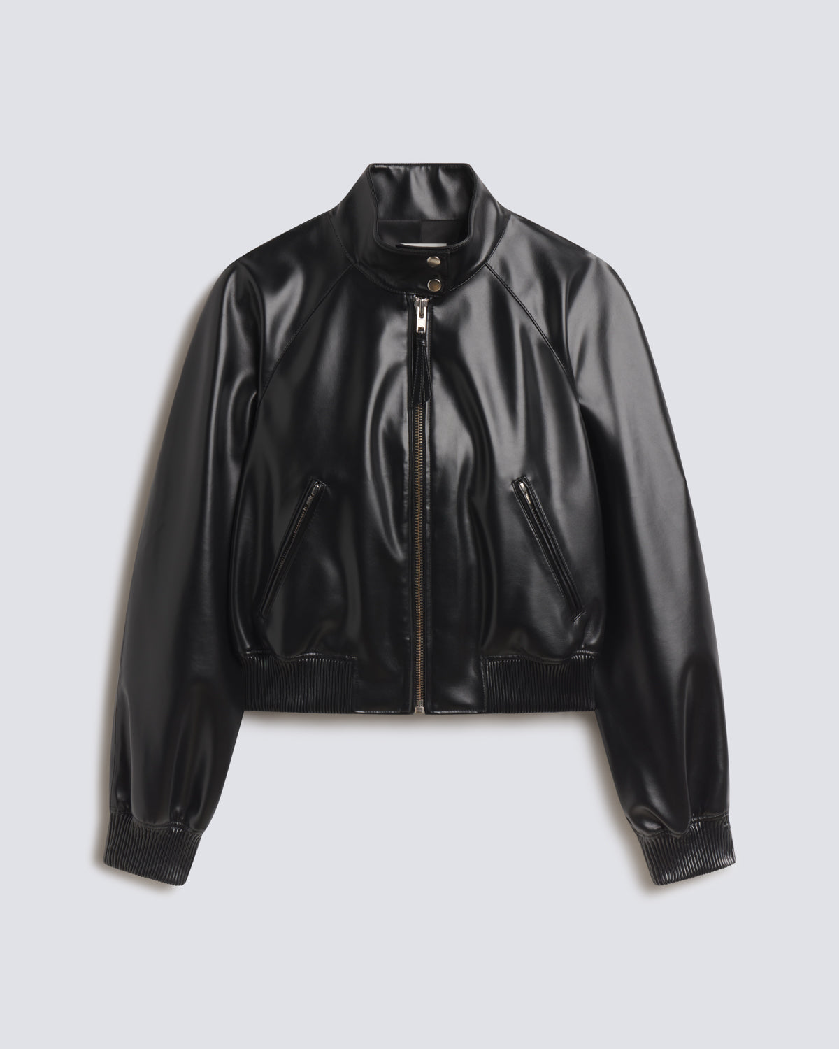 A black faux leather cropped bomber jacket with a stand-up collar, front zipper, and zippered side pockets, displayed on a light gray background.