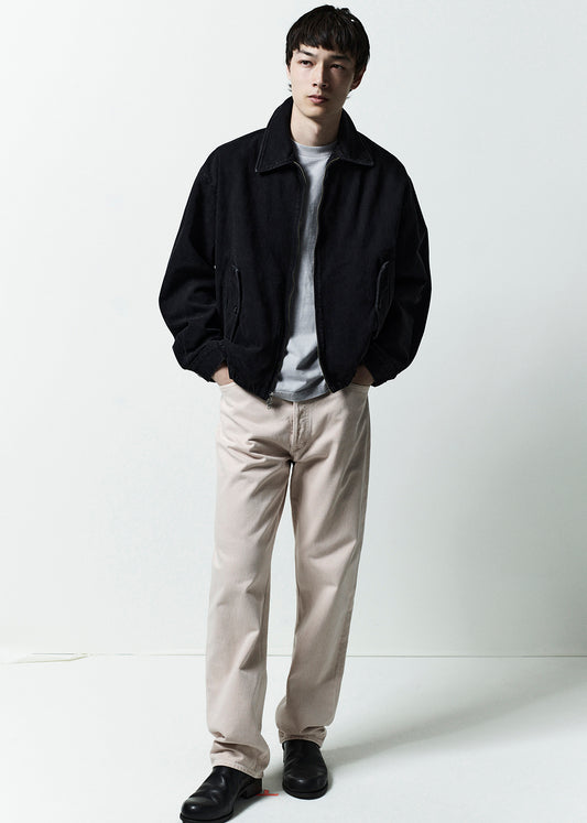 Man wearing a black jacket, white shirt, beige pants, and black shoes on a white background
