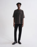 Person wearing a dark t-shirt and black pants on a white background