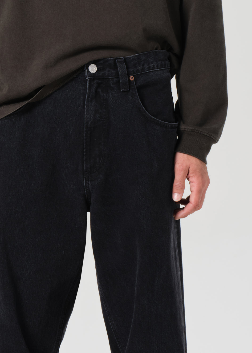 Person wearing black pants and a dark shirt on a white background