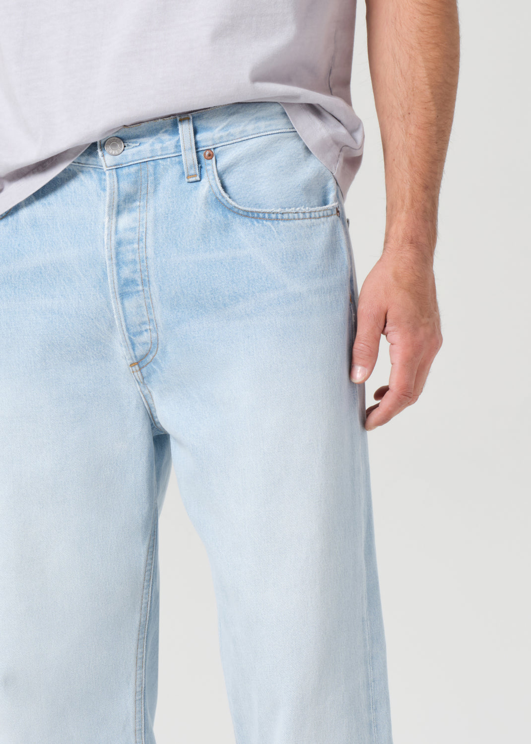 Light blue jeans worn by a person on a plain background