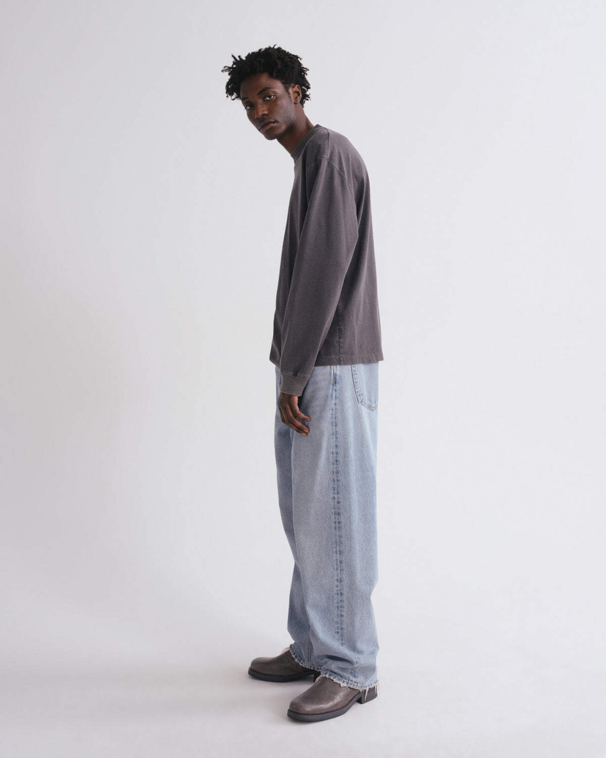 Person wearing a long-sleeve shirt and jeans on a white background