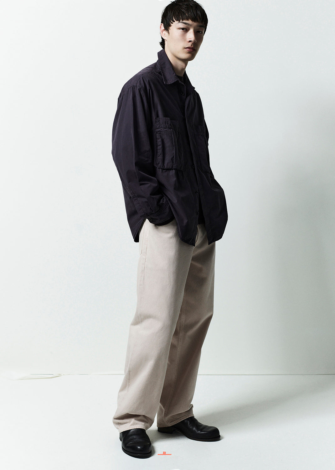 Person wearing a dark shirt and light pants on a white background