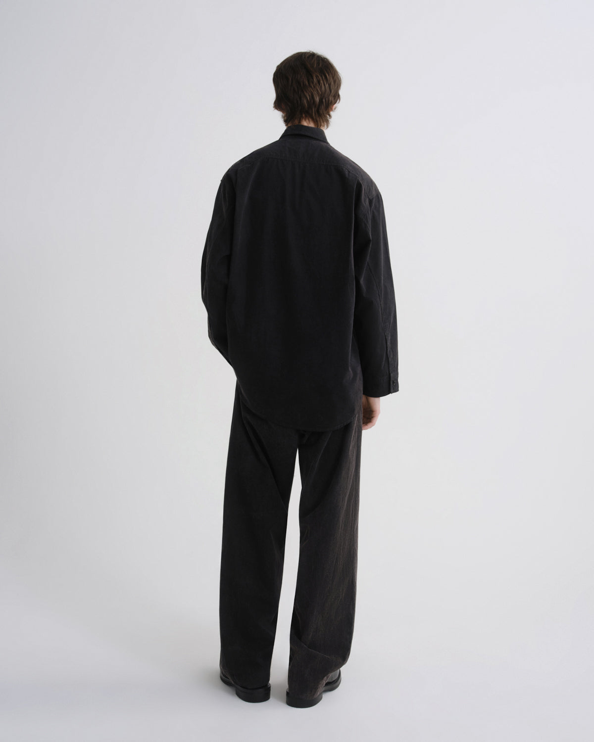 Person wearing a black outfit on a white background