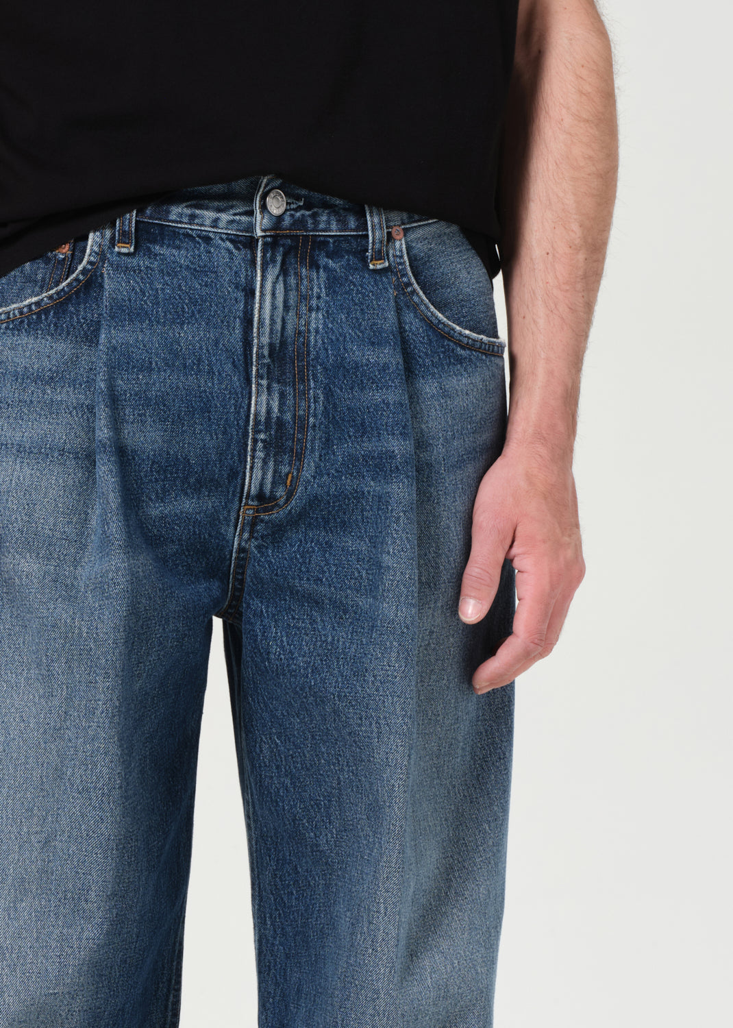 Person wearing blue jeans on a plain background