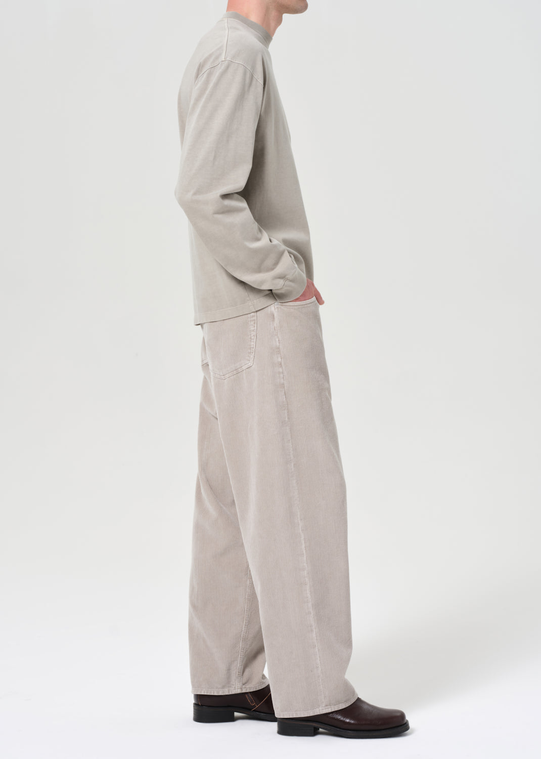 Person wearing a light gray outfit with wide-leg pants on a white background