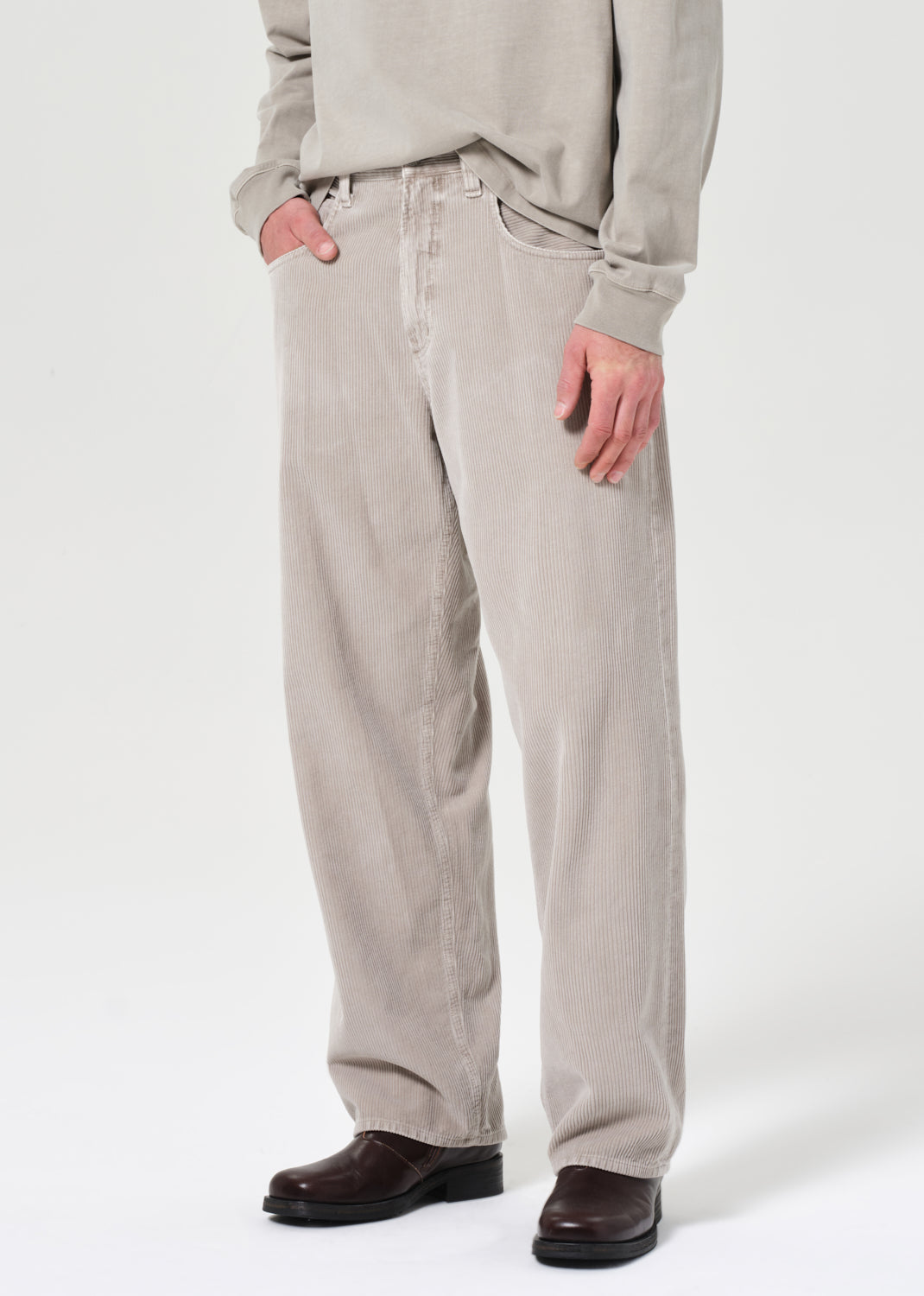 Person wearing beige pants and a light gray sweatshirt on a white background