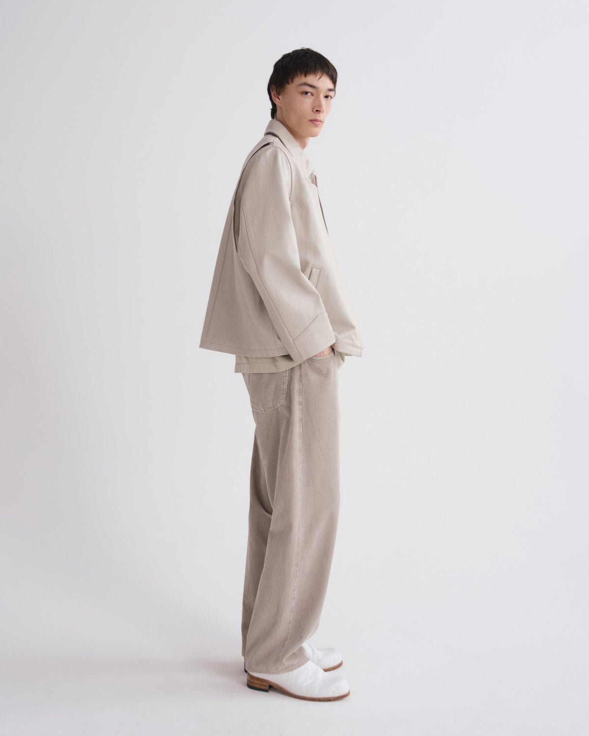 Person wearing a beige outfit on a white background