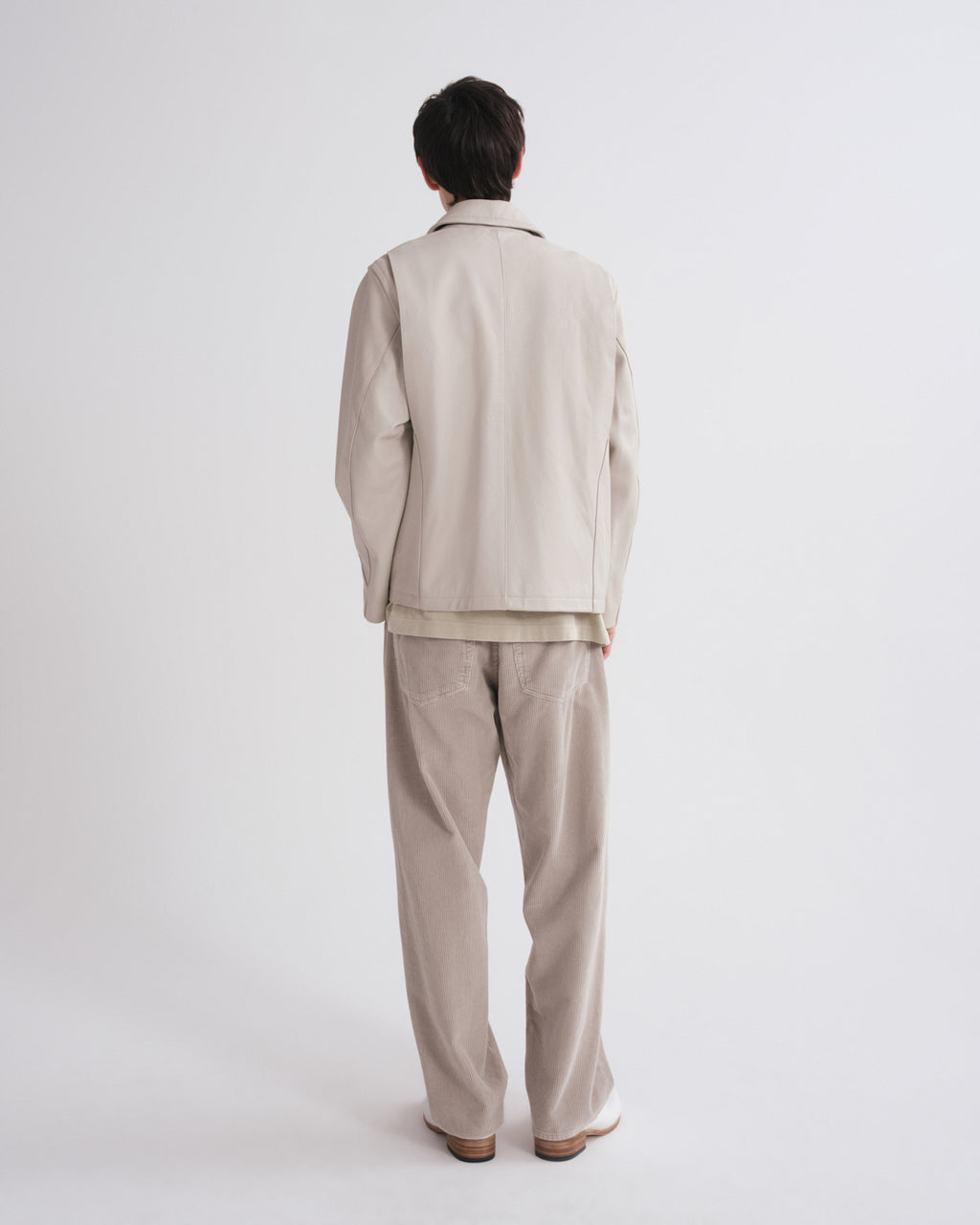 Person wearing a beige suit on a white background