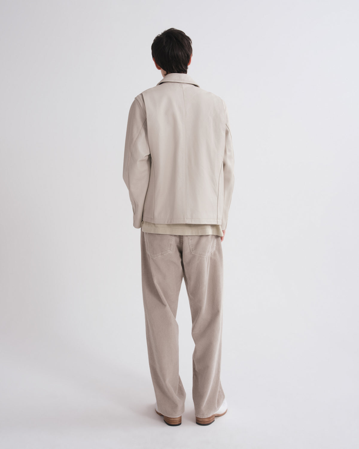 Person wearing a beige suit on a white background