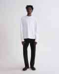 Person wearing a white long-sleeve shirt and black pants on a white background