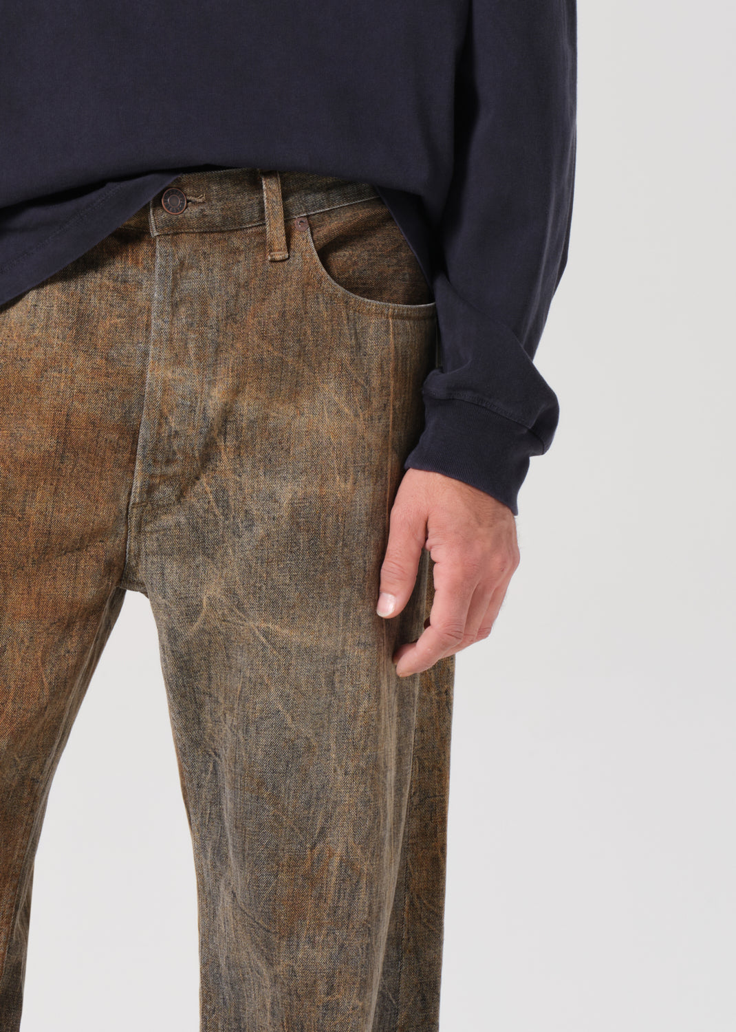 Brown pants worn by a person on a plain background