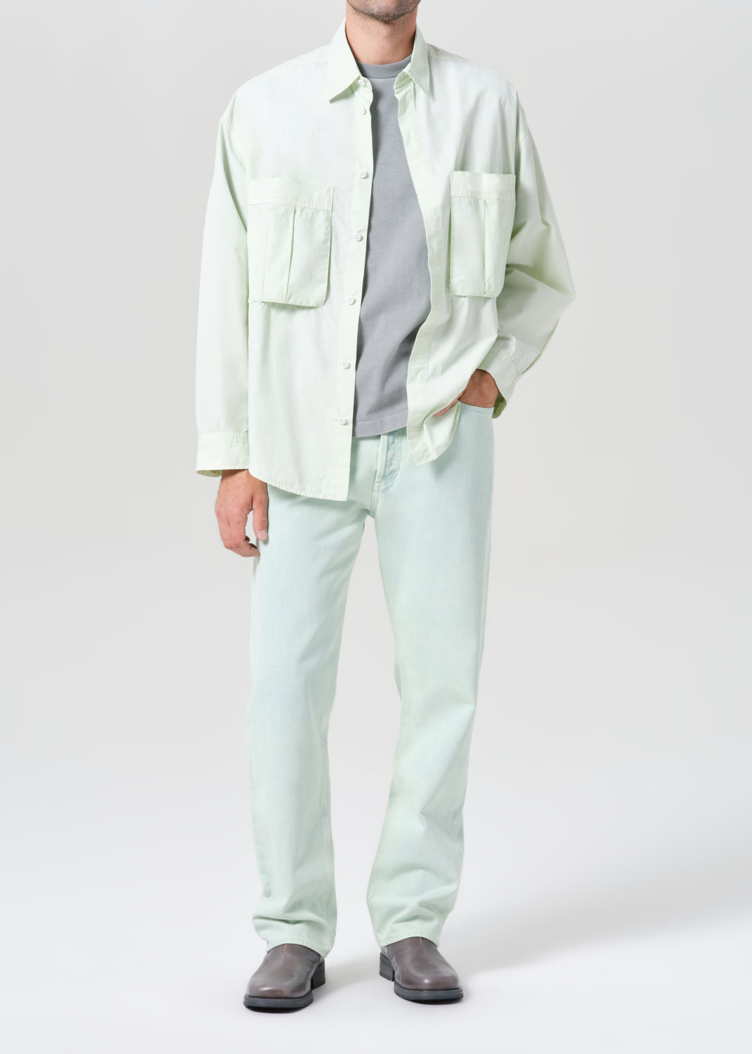 Person wearing a light green shirt and pants on a white background